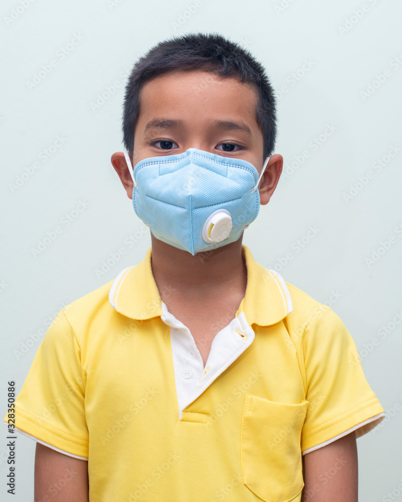 Asian boy wears a protective mask. (COVID-19) Asian boy wears a protective mask. (COVID-19)