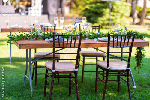 Preparing for an open-air party. Decorated served tables await guests. Decoration Details © Kate