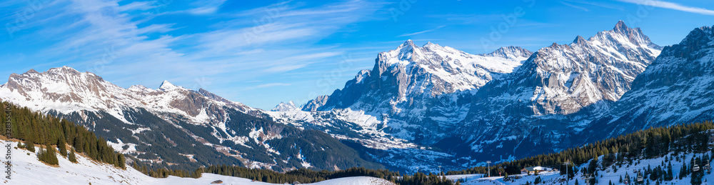 Wide parnoramic view of snow covered Swiss Alps in Grindelwald ski resort in the winter