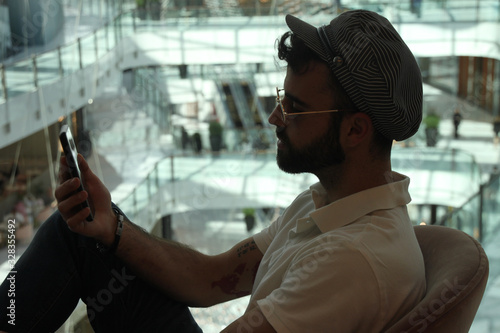 Man calling with his smart phone in a Dubai mall. Fashion and technology concept