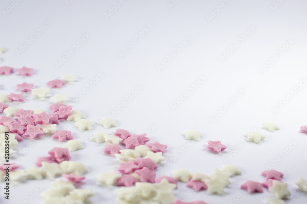 Sugar stars in pink and white colour, cake decorating sweets on white background, copy spce for text