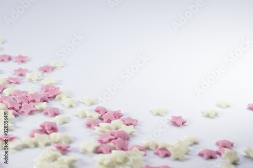 Sugar stars in pink and white colour, cake decorating sweets on white background, copy spce for text