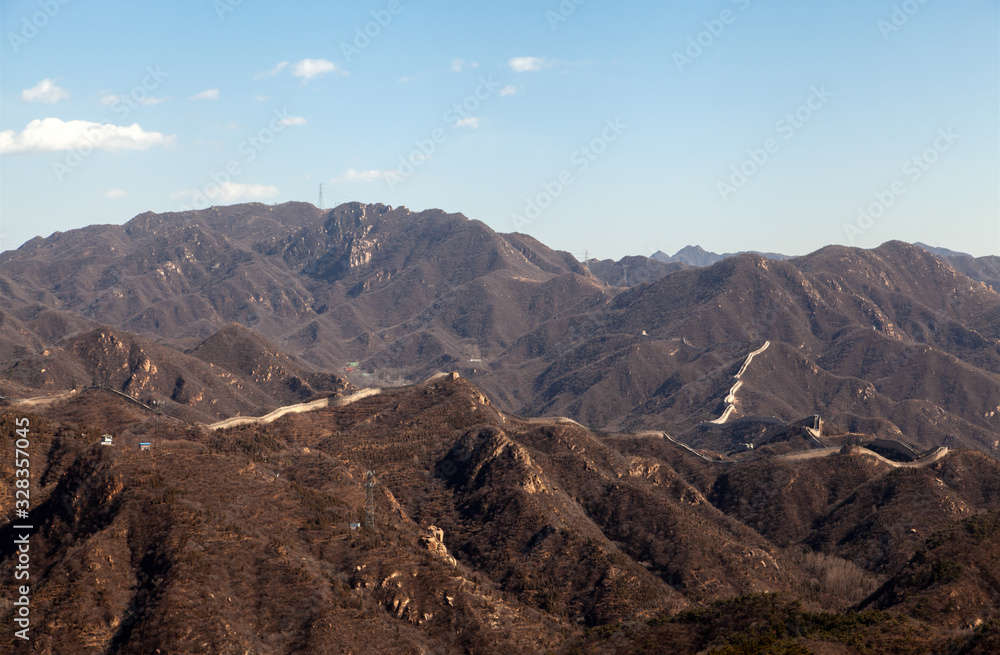 Long Chinese Great Wall on brown hilly landscape 