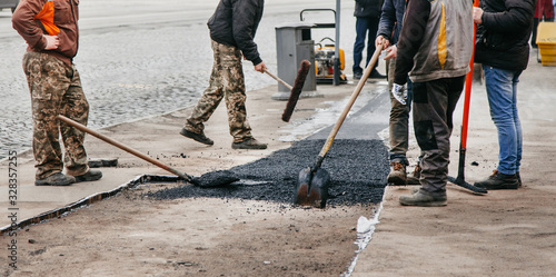 workers lay new asphalt on the track