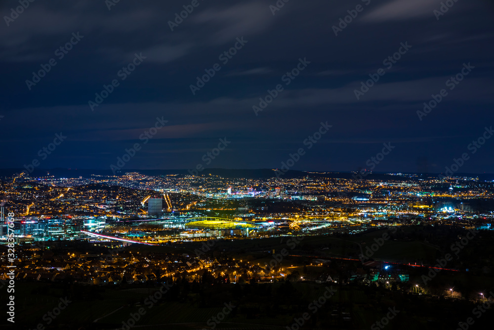 Germany, Magical illuminated skyline of stuttgart city, arena, industry, houses and streets by night, aerial view above