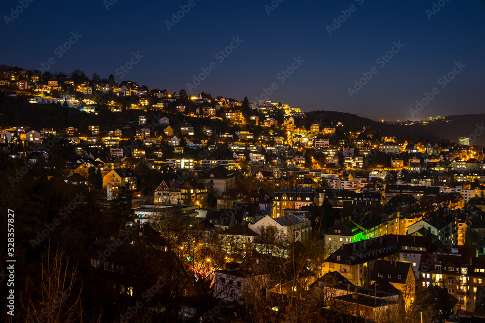 Germany, Night sky over illuminated cityscape of stuttgart heslach houses by night, aerial view above skyline