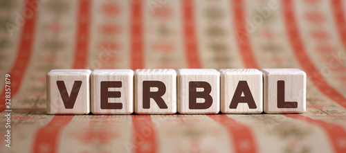 Verbal word on wooden cubes on a color background photo