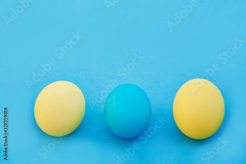 Easter blue and yellow eggs on blue background. Greeting Easter Spring Card