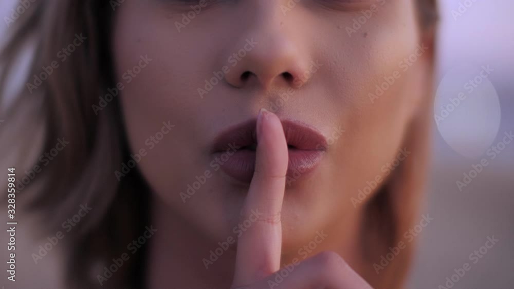 Adorable sexy female mouth showing gesture silence by hand zoom in seductive woman lips Adorable sexy female mouth showing gesture silence by hand zoom in seductive woman lips