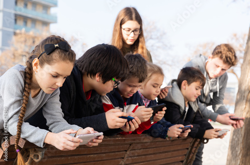 Children are playing on smartphone in the playground