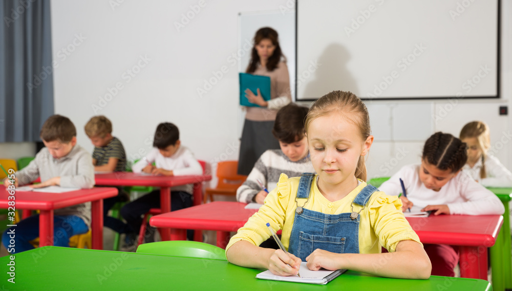 Schoolgirl writing at lessons