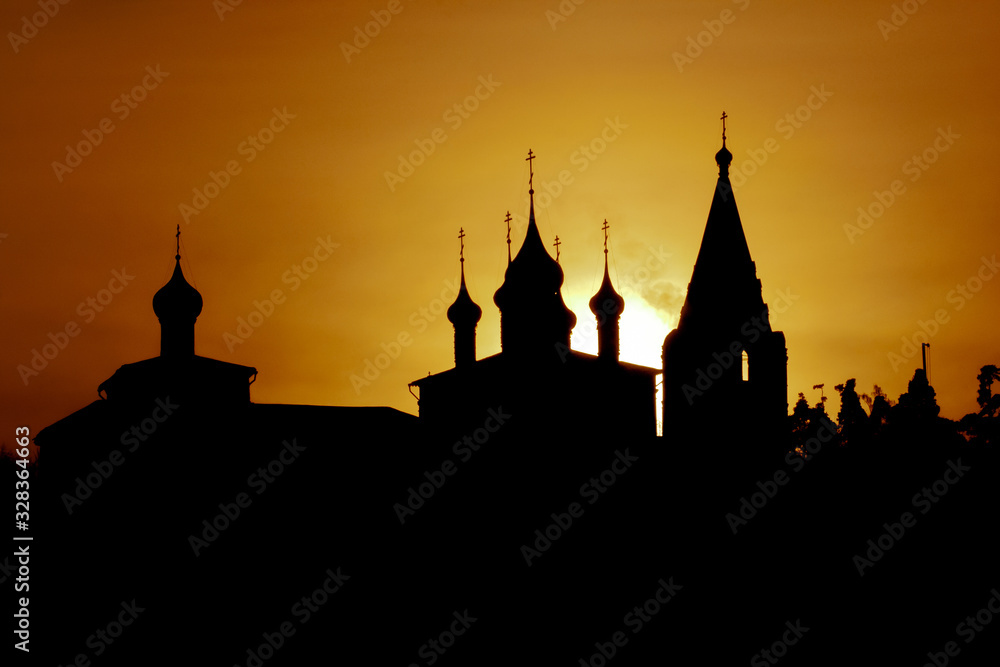 Silhouette of russian orthodox church in front of evening sun.