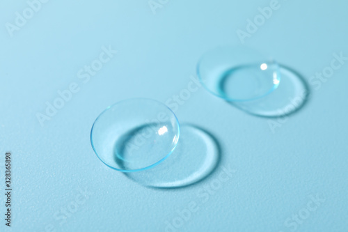 Contact lenses on blue background  close up