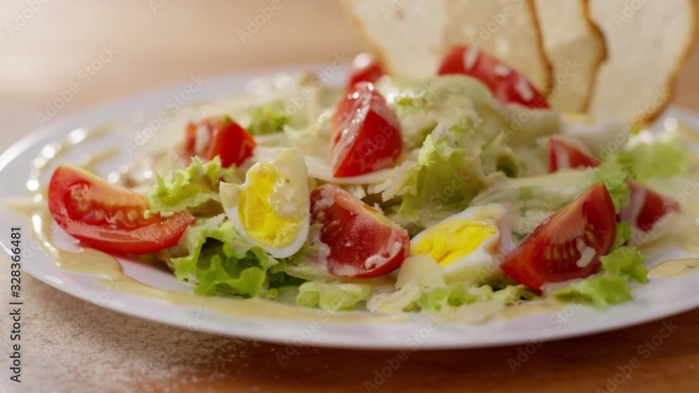 Close up view of caesar salad with tomato parmesan cheese lettuce cheese cuisine meat green lunch plate meal food chicken vegetable healthy fresh appetizer dish slow motion Close up view of caesar salad with tomato parmesan cheese lettuce cheese cuisine meat green lunch plate meal food chicken vegetable healthy fresh appetizer dish slow motion