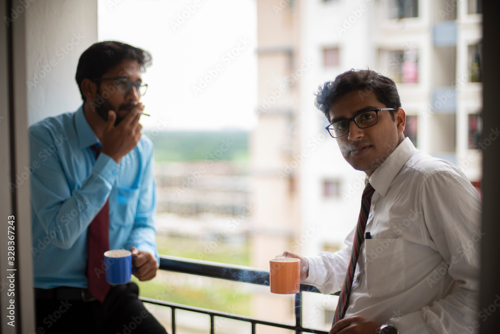 Corporate meetings with coffee/tea and cigarette between young and energetic Indian Bengali bosses/officers/managers at balcony of the office building regarding a project. Indian corporate lifestyle Corporate meetings with coffee/tea and cigarette between young and energetic Indian Bengali bosses/officers/managers at balcony of the office building regarding a project. Indian corporate lifestyle