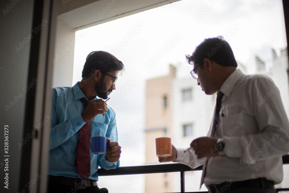 Corporate meetings with coffee/tea and cigarette between young and energetic Indian Bengali bosses/officers/managers at balcony of the office building regarding a project. Indian corporate lifestyle Corporate meetings with coffee/tea and cigarette between young and energetic Indian Bengali bosses/officers/managers at balcony of the office building regarding a project. Indian corporate lifestyle