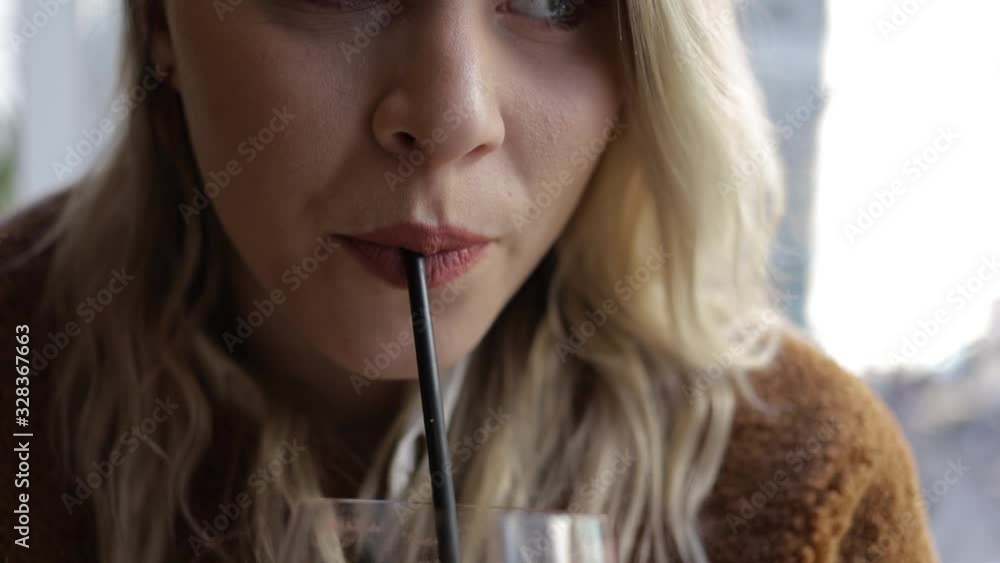 close up view of a Caucasian woman enjoying a refreshing alcoholic tea beverage at a local cafe in the city. drinking the delicious drink she is dressed fashionably in fall clothing lifestyle close up view of a Caucasian woman enjoying a refreshing alcoholic tea beverage at a local cafe in the city. drinking the delicious drink she is dressed fashionably in fall clothing lifestyle