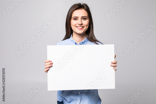 Beautiful young woman holding a blank billboard isolated on white background