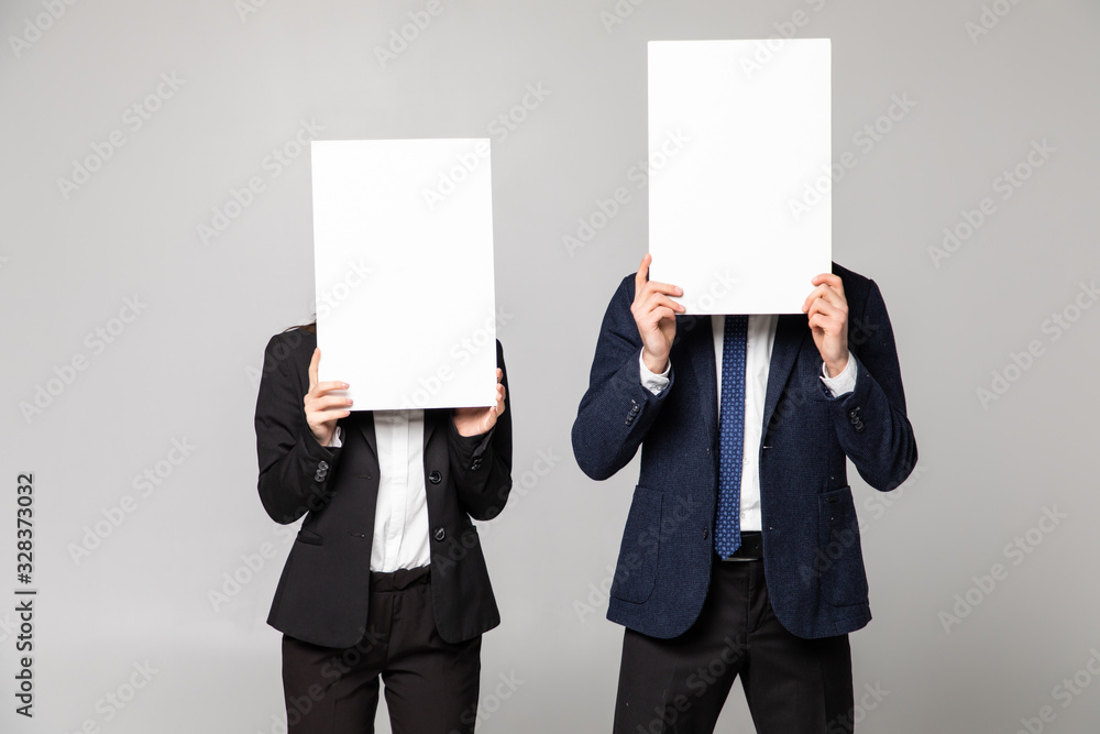 Business couple holding paper over their faces on white background Business couple holding paper over their faces on white background