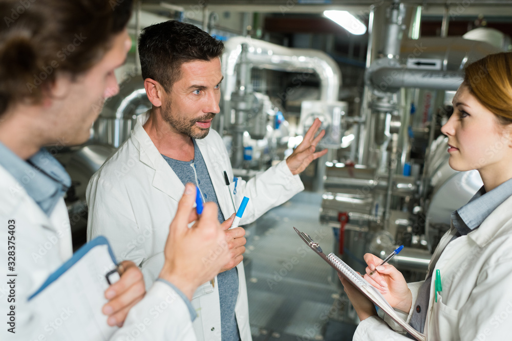 Fototapeta premium workers in lab coats working in a factory