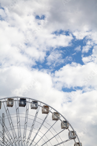 Ferris wheel on background of cloudy sky