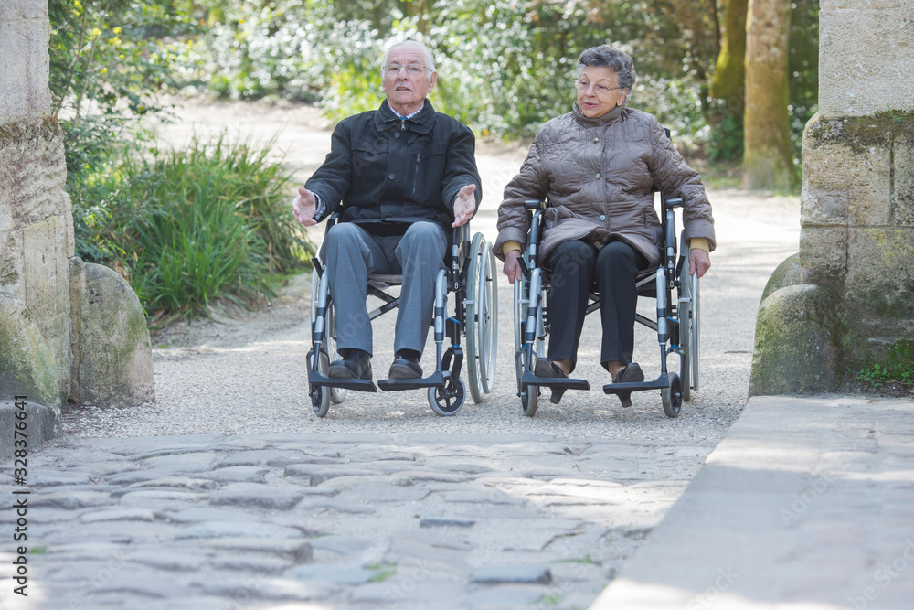 senior couple wandering on their wheelchairs senior couple wandering on their wheelchairs
