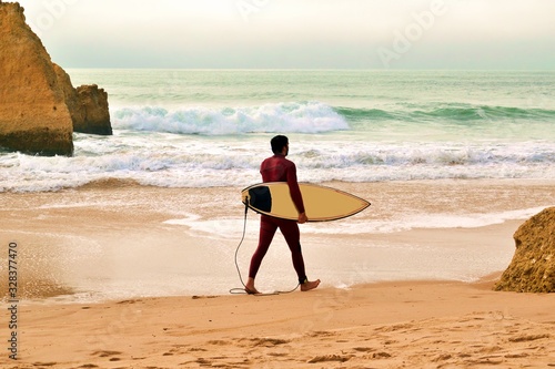 surfista sulla spiaggia dos Três Irmãos situata ad Alvor nell'Oceano Atlantico nella regione dell'Algarve in Portogallo