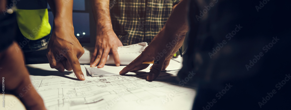 Construction engineers discussion with team members at meeting room with construction drawing on Desk, Pointed directly to the startup. Construction Business Banner background. - obrazy, fototapety, plakaty 