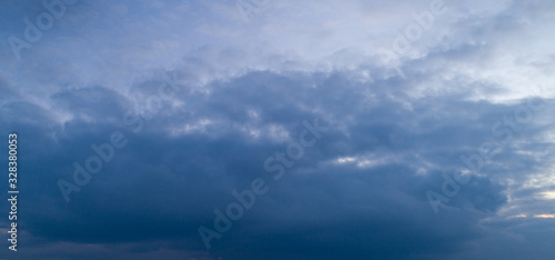 Dark cloudy sky with red reflections at sunset.