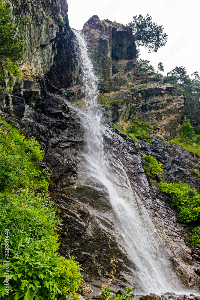 Fototapeta premium waterfall flowing down a steep cliff in the mountains