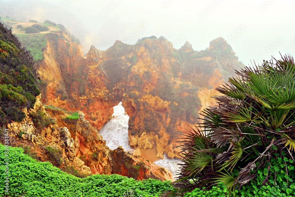veduta delle caratteristiche formazioni rocciose vicino alla spiaggia dos Três Irmãos in una giornata di fitta nebbia ad Alvor sulla costa dell'Algarve in Portogallo