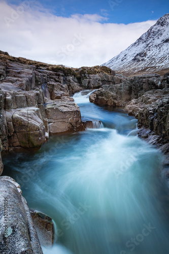 long exposure shot of the waterfalls in glen etive near loch etive and the entrance to glencoe and rannoch moor in the argyll region of the highlands of scotland during winter