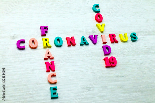 Coronavirus COVID-19 in FRANCE - Rainbow colored wood letters on grey wooden background