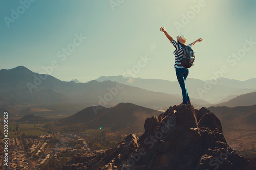 Joven mujer feliz en la cima de una montaña