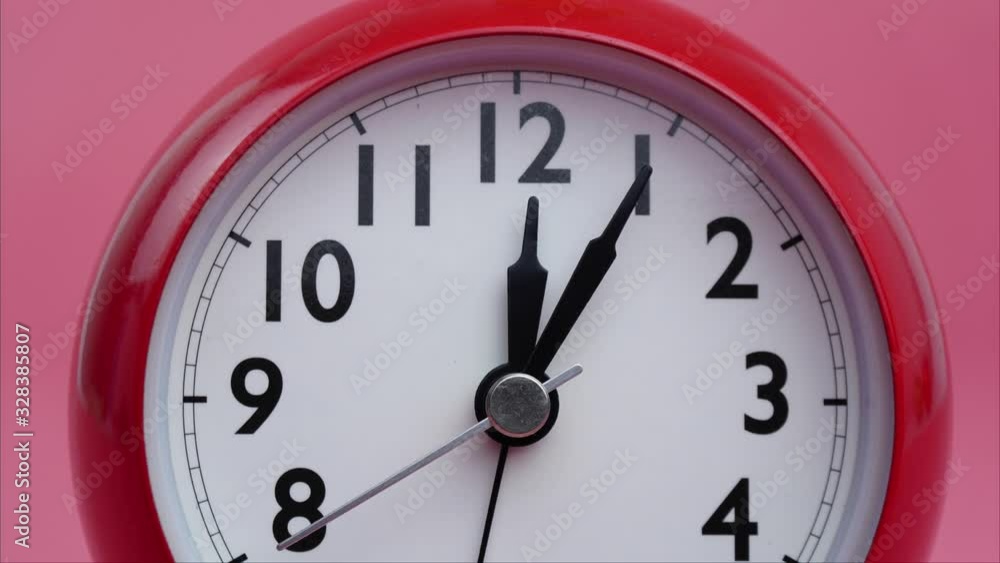 Closeup Twelve o'clock Red Alarm clock on pink Background, Rush hour eat lunch, Time lapse moving fast. Closeup Twelve o'clock Red Alarm clock on pink Background, Rush hour eat lunch, Time lapse moving fast.