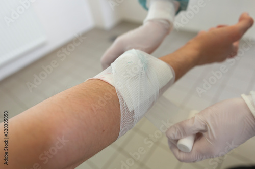 A doctor puts on a pressure bandage in a hospital