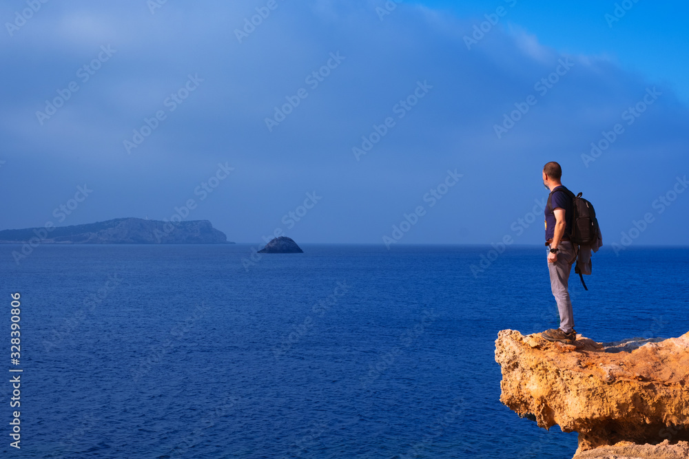 Senior tourist looking at the landscape and the sea from Cala Bassa, Ibiza, Balearic Islands