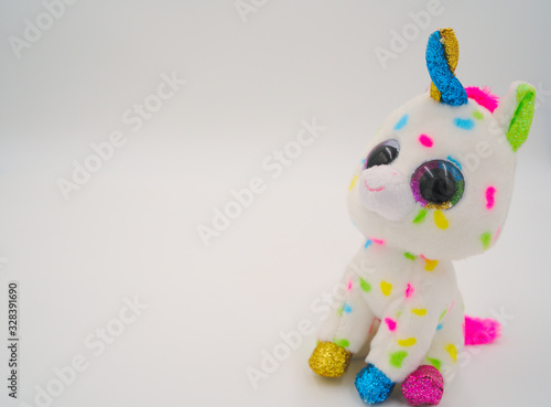 Magical unicorn plush toy on white background