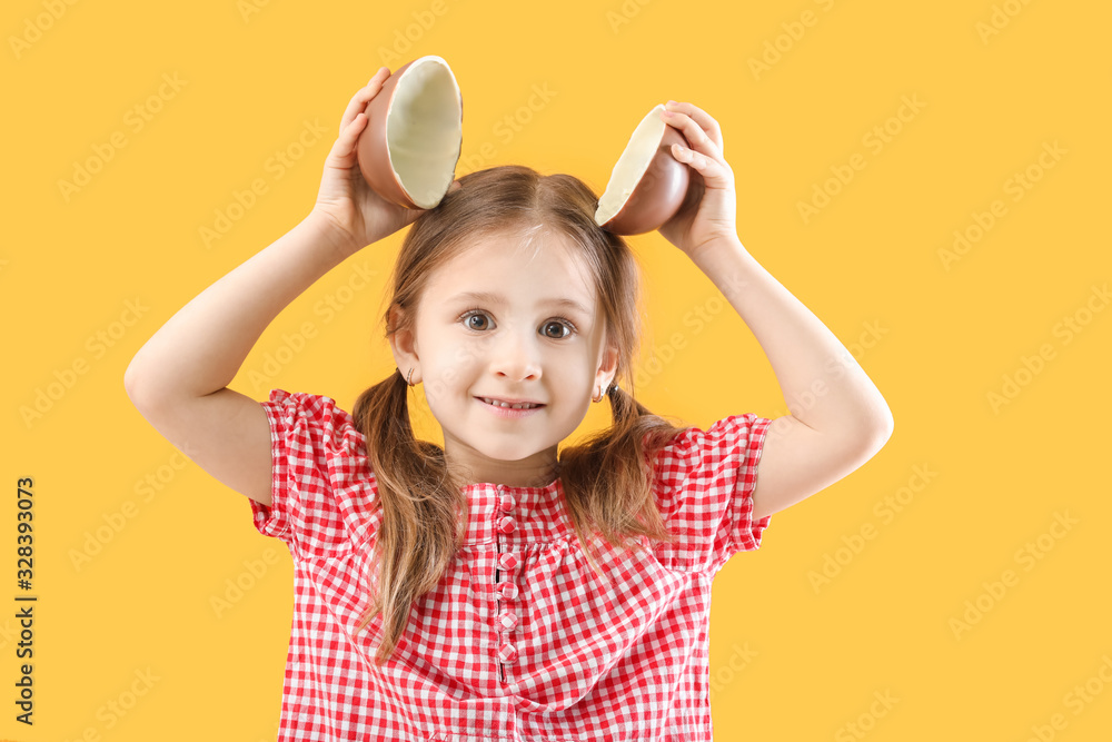Cute little girl with sweet chocolate egg on color background Cute little girl with sweet chocolate egg on color background