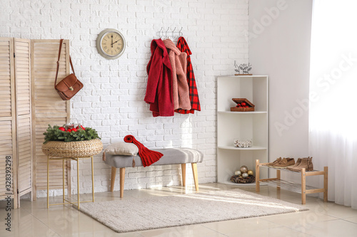 Stylish interior of modern hall with winter clothes