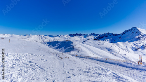 Beautiful mountain range covered in snow with clear sky on sunny day. Ski infrastructure and slopes in Pyrenees, Andorra © Dawid