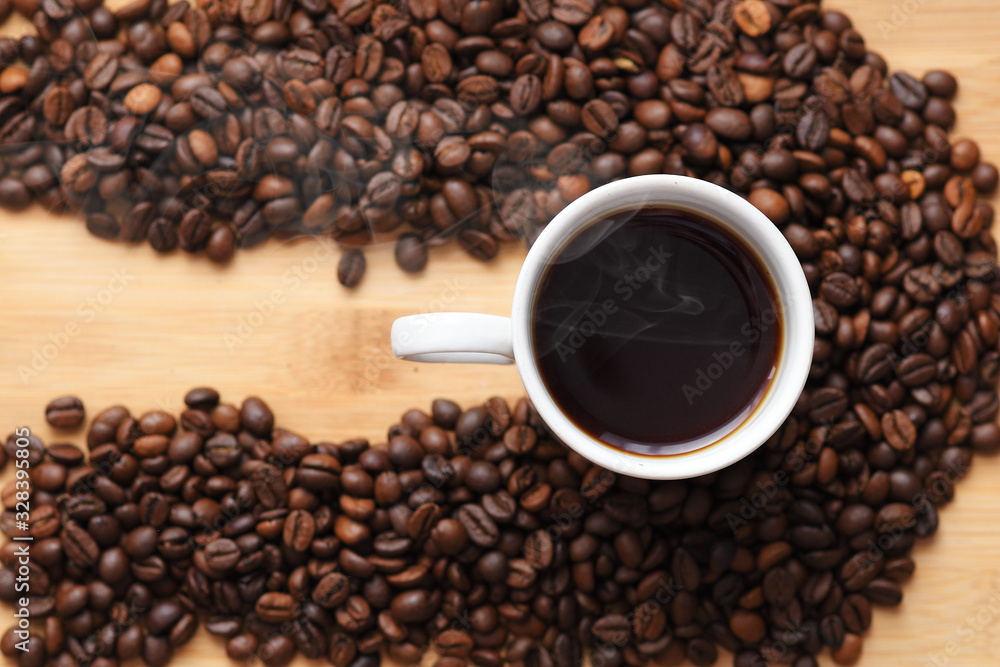 white Cup with hot coffee surrounded by coffee beans on wooden surface. with place under the inscription white Cup with hot coffee surrounded by coffee beans on wooden surface. with place under the inscription
