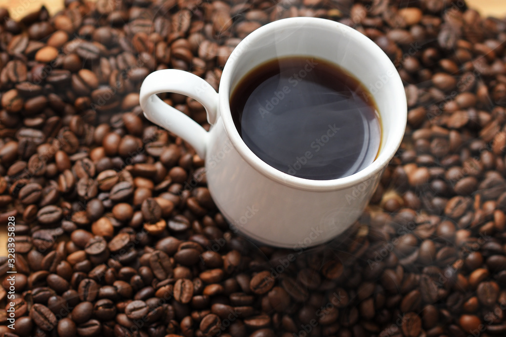 Cup of hot coffee on coffee beans background Cup of hot coffee on coffee beans background