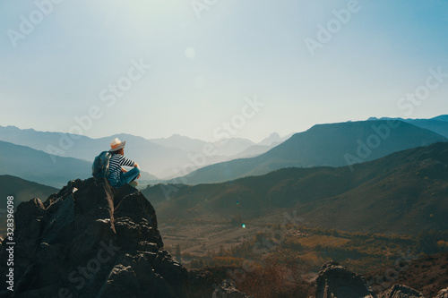 Mujer joven contemplando el horizonte en la cima de una montaña