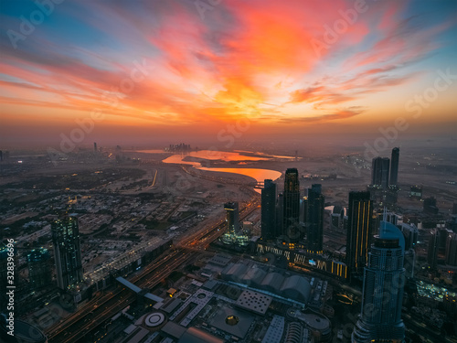 Beautiful sunrise above Dubai skyline, United Arab Emirates, aerial panoramic view from rooftop of skyscraper. © DedMityay