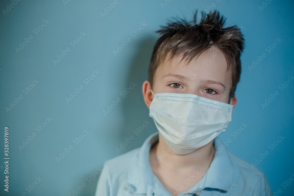 boy in medical mask on blue background. child with flu, influenza or cold protected from viruses, pollution in bad epidemic situation, among patients with coronavirus boy in medical mask on blue background. child with flu, influenza or cold protected from viruses, pollution in bad epidemic situation, among patients with coronavirus