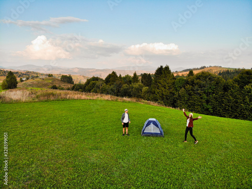 Aerial view of love couple of hikers spend time together away from city bustle by sunrise in camping day