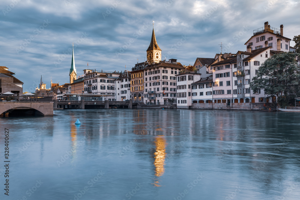 Famous Fraumunster and Church of St Peter with reflections in river Limmat at sunrise in Old Town of Zurich, the largest city in Switzerland