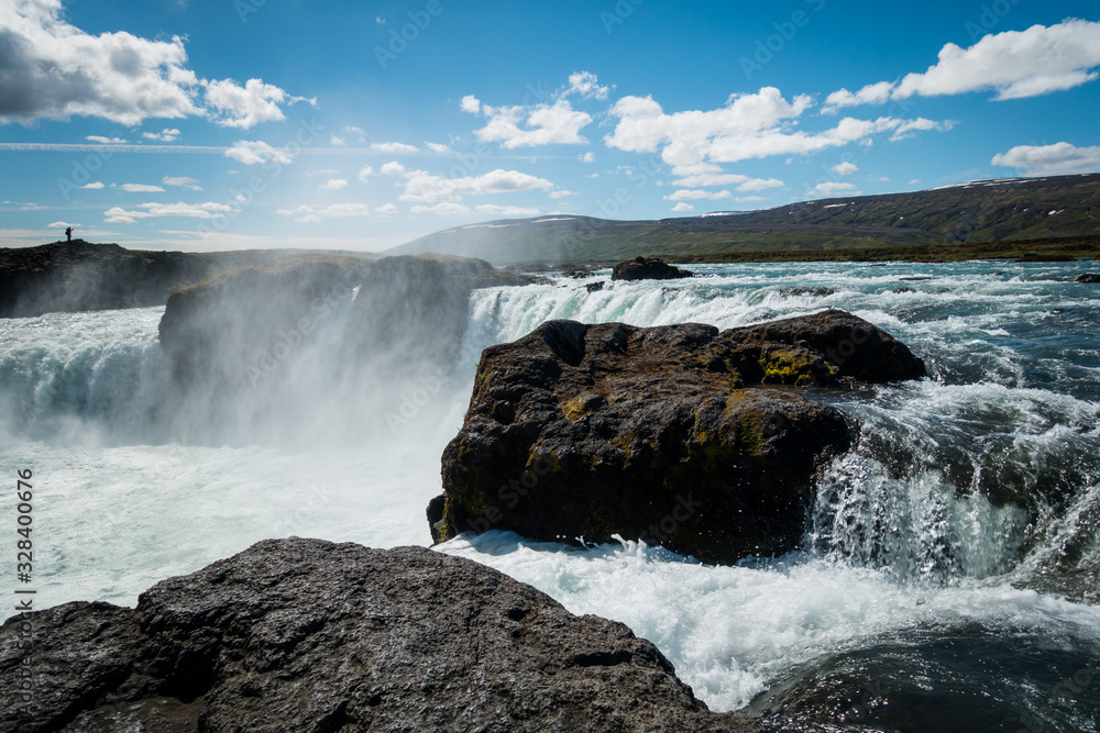 Mighty Godafoss waterfall near Akureyri Iceland on beautiful sunny day with mist hanging in air