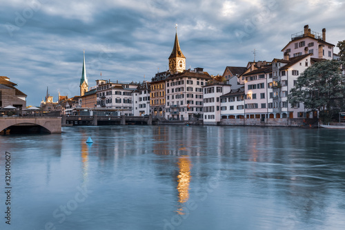 Famous Fraumunster and Church of St Peter with reflections in river Limmat at sunrise in Old Town of Zurich, the largest city in Switzerland